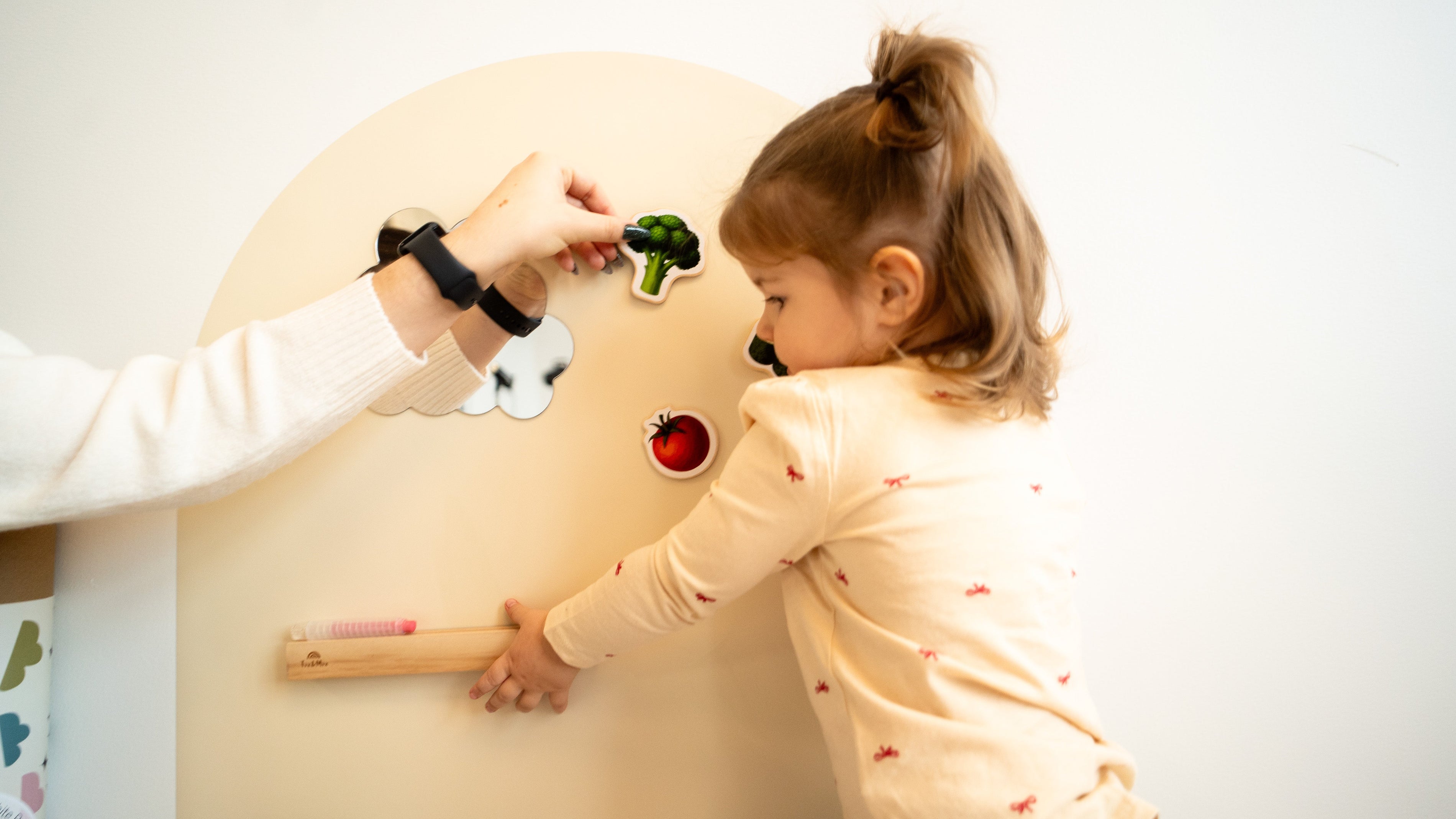 A child playing with DIY magnets on Tix & Mix magnetic wall decal.