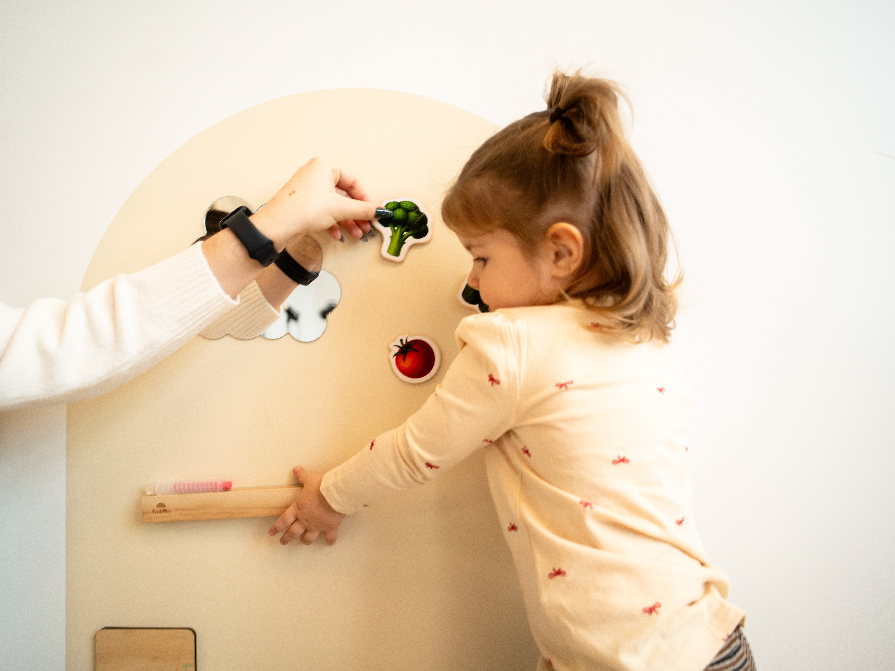 A child playing with DIY magnets on Tix & Mix magnetic wall decal.