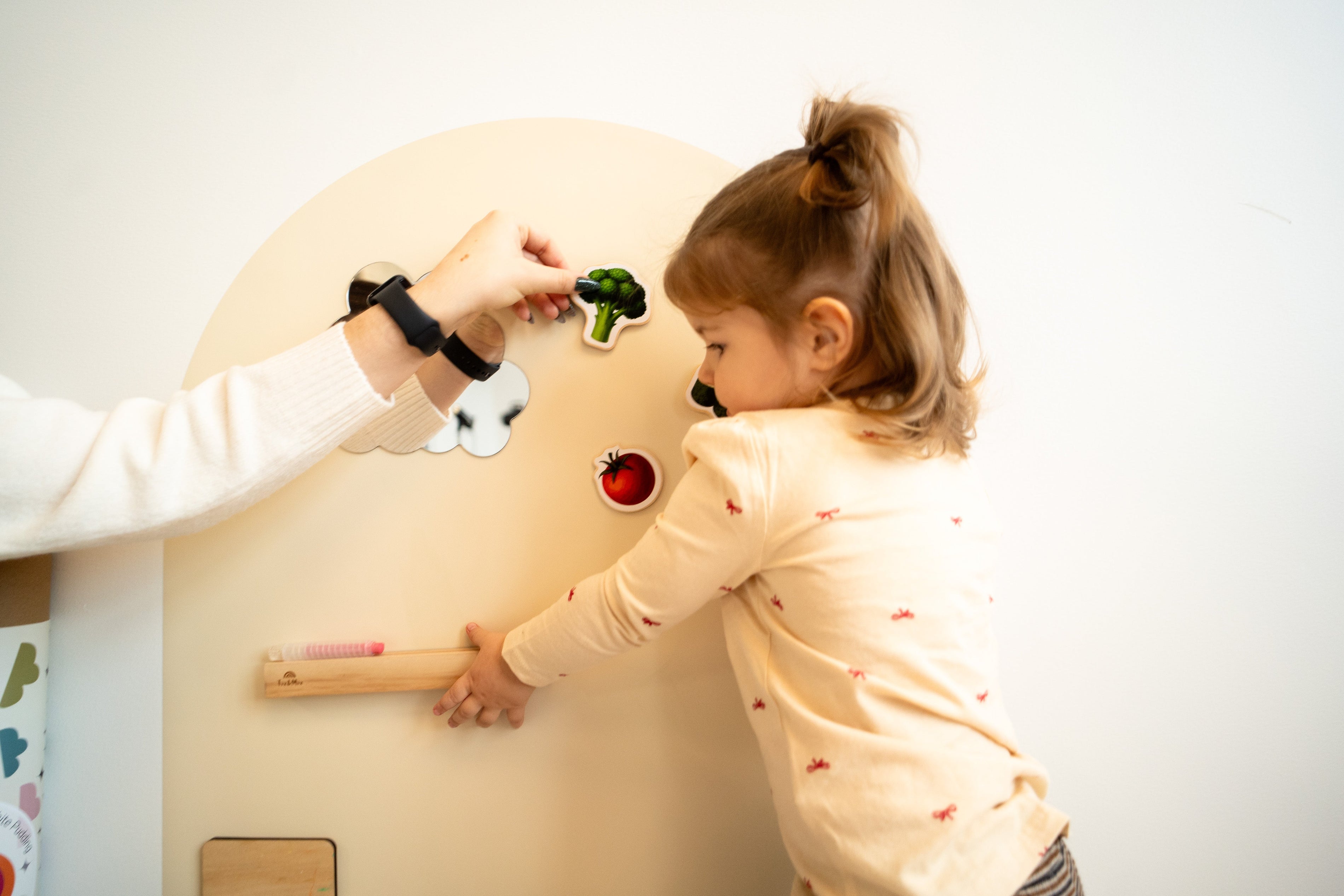 A child playing with DIY magnets on Tix & Mix magnetic wall decal.