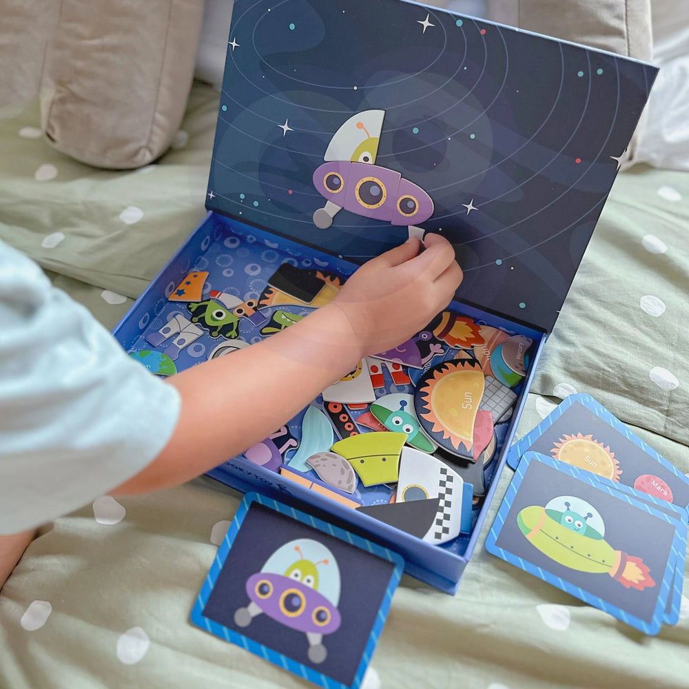 A kid organizing a part of Tix&Mix space exploration toy inside the packaging box.