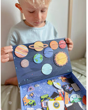 A male kid holding a Tix&Mix space exploration playset box.