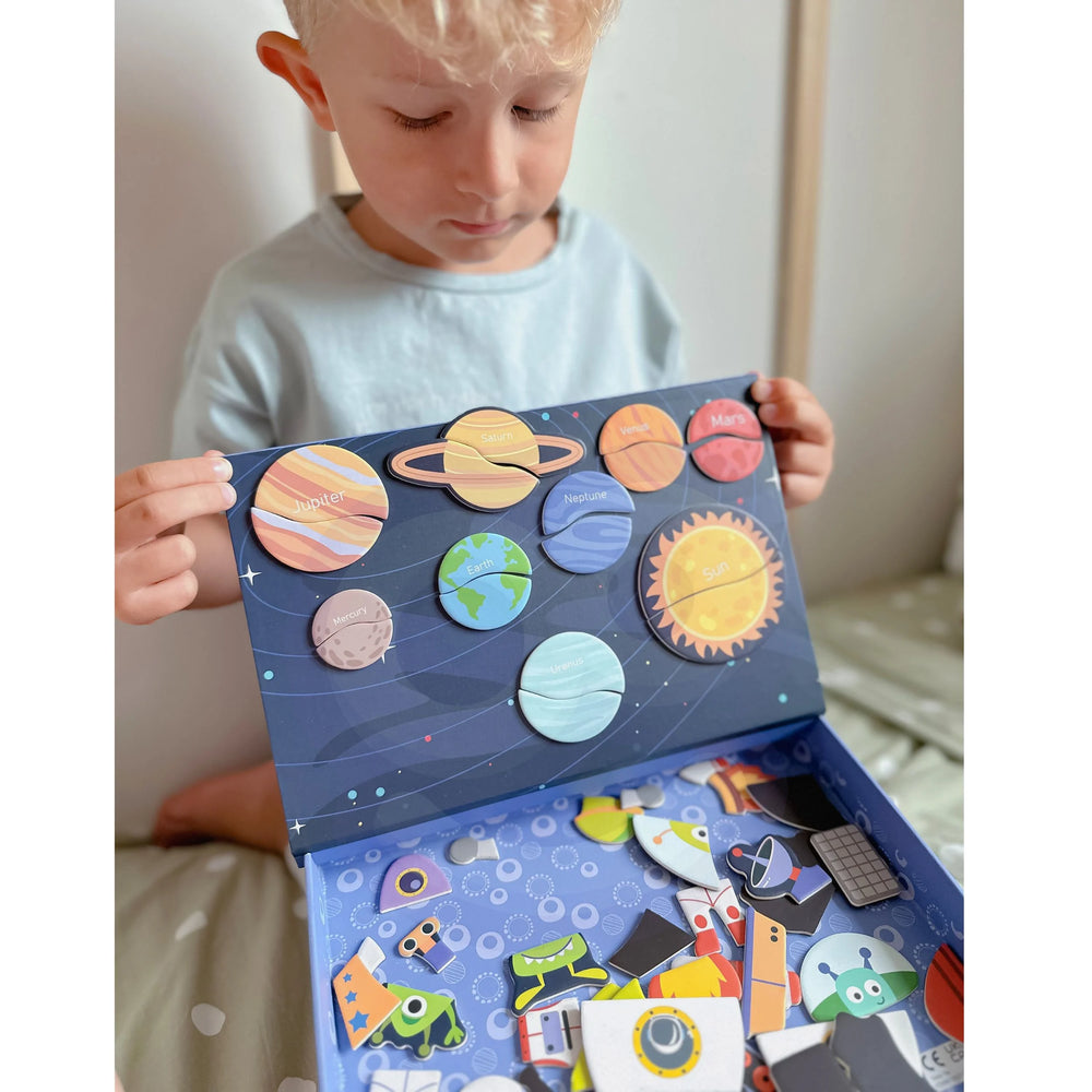 A male kid holding a Tix&Mix space exploration playset box.