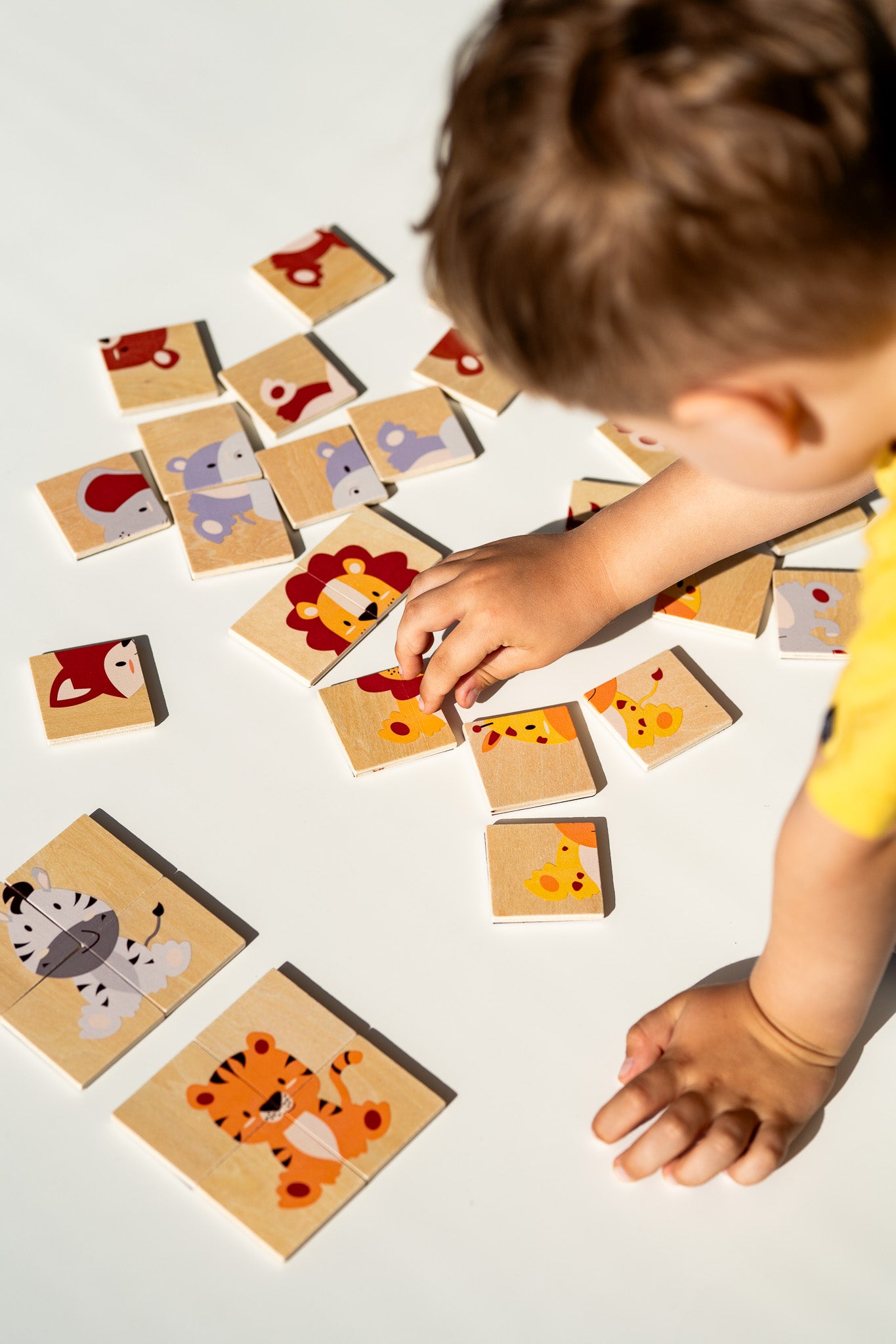 A toddler playing with Tix&Mix animal puzzle set.