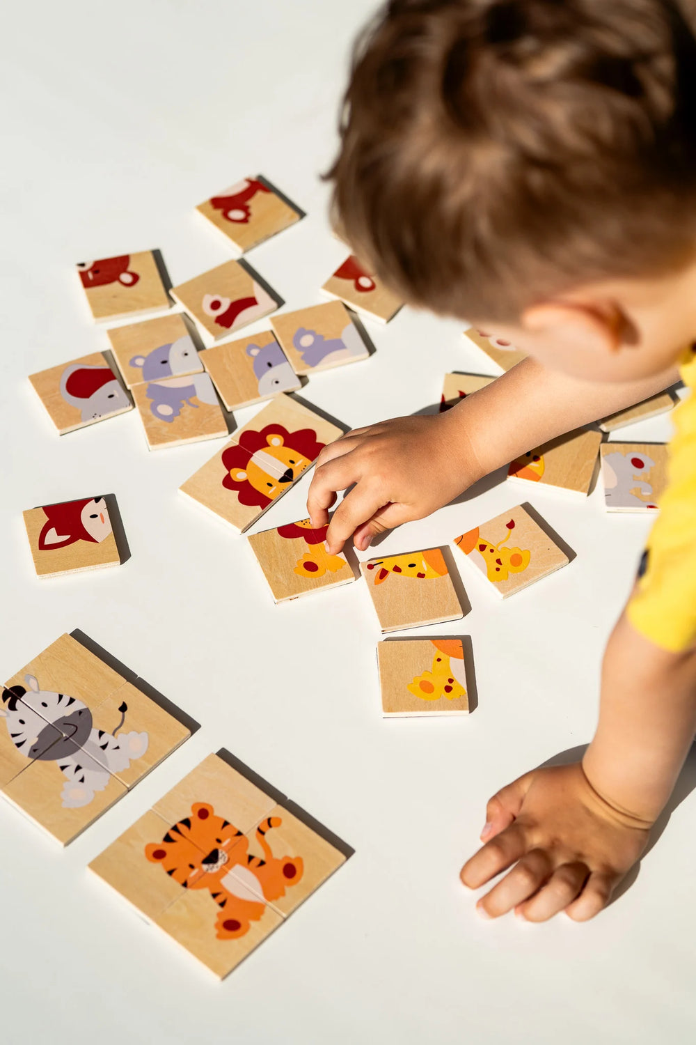 A toddler playing with Tix&Mix magnetic animals puzzle set.