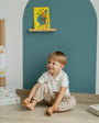 A kid sitting comfortable in front of Tix&Mix magnetic wall decal.
