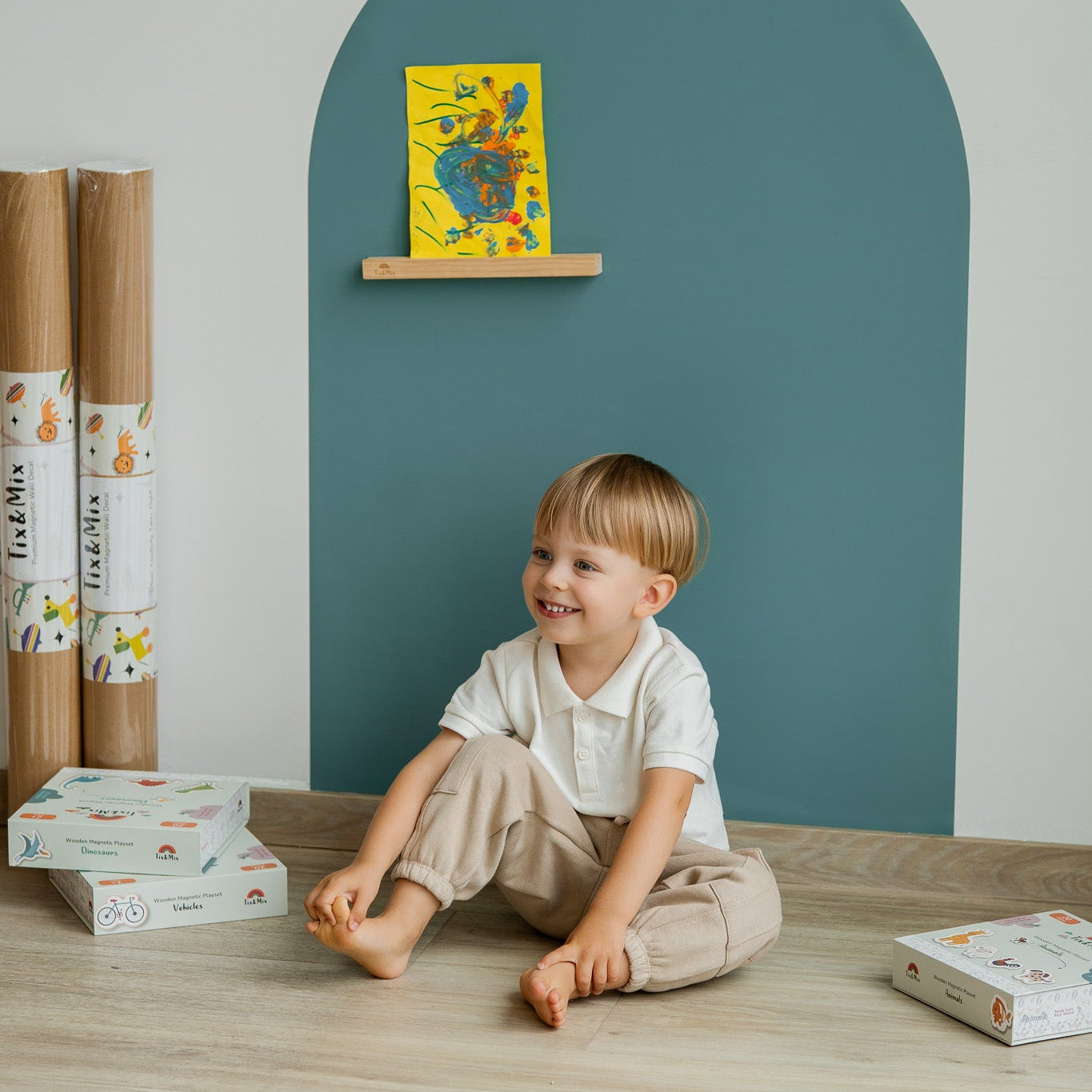 A kid sitting comfortable in front of Tix&Mix magnetic wall decal.