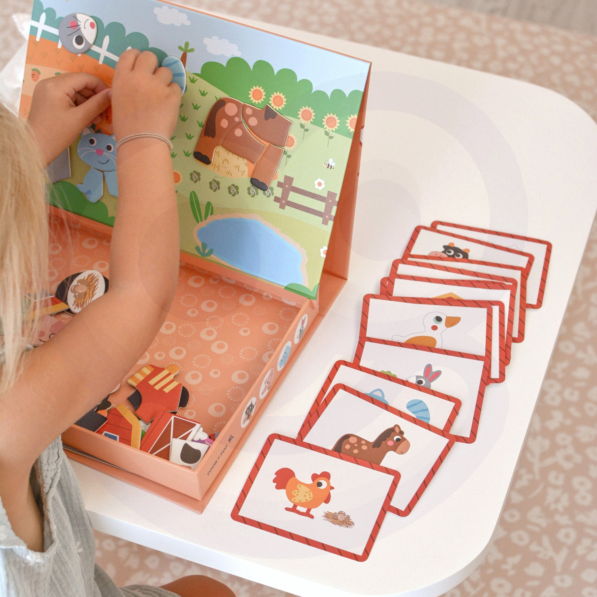 A female kid playing with Tix&Mix magnetic farm toys.
