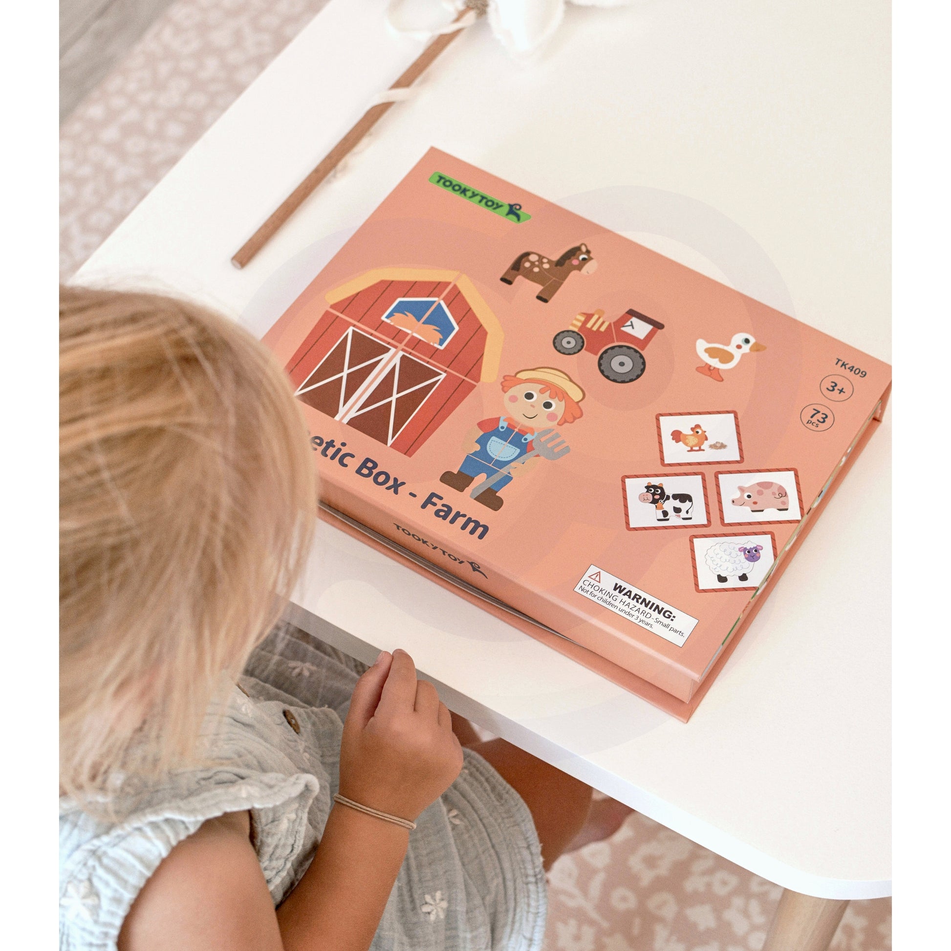A new Tix&Mix magnetic box farm on a clean white table with a female kid on the side.