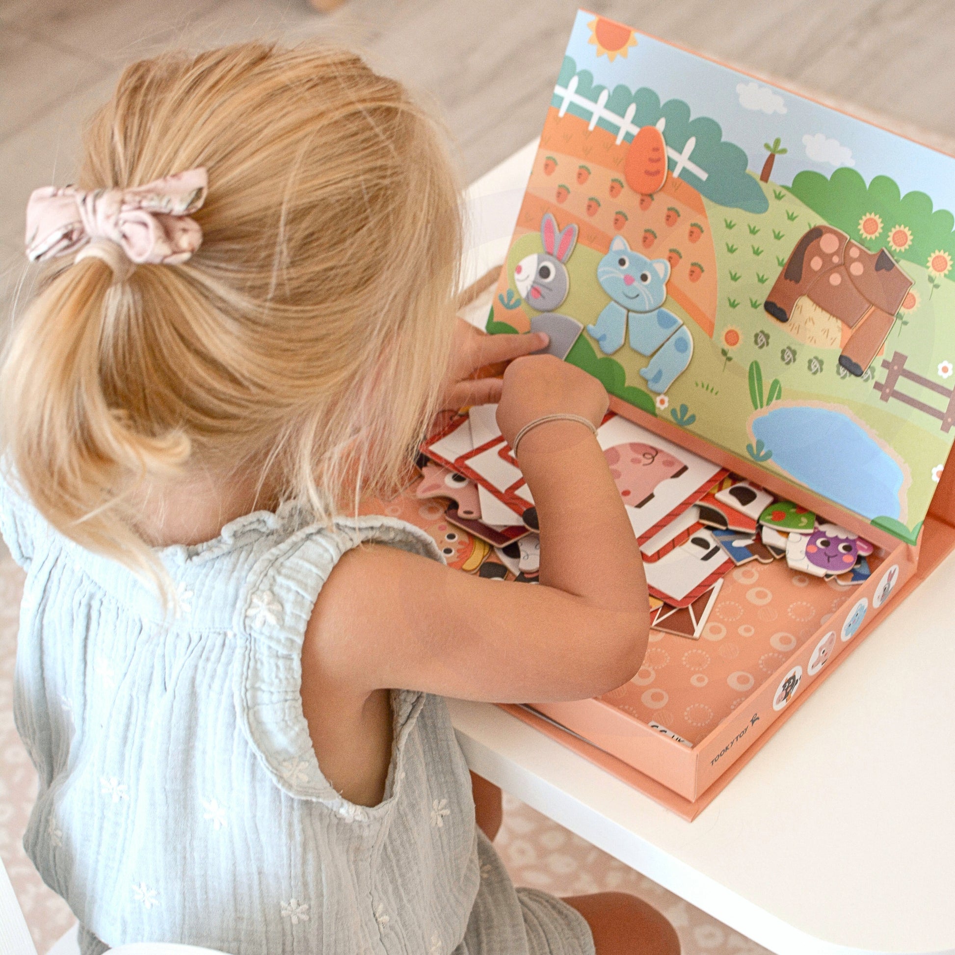 A female kid playing with Tix&Mix magnetic farm animals set.