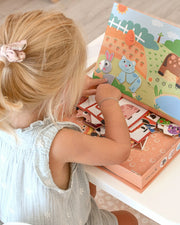 A female child playing with Tix&Mix farm discovery set with its packaging box.