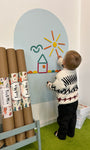 A toddler playing with rings and blocks lay kit on a Tix&Mix premium magnetic grey wall decal.