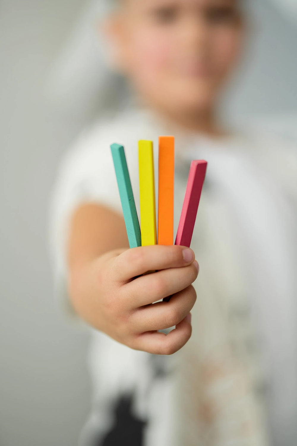 A kid holding samples of Tix&Mix Rings and Blocks playset.