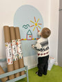 A toddler playing with Tix&Mix Rings and Blocks play set on a cyan blue magnetic wall decal.