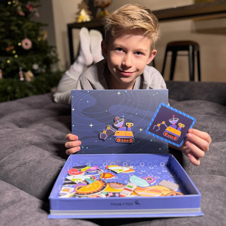 A male kid confidently looking at the camera while holding Tix&Mix space exploration toy set.