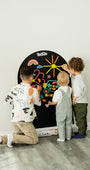 Three kids playing with Tix&Mix rings and block play kit on a black magnetic wall decal.