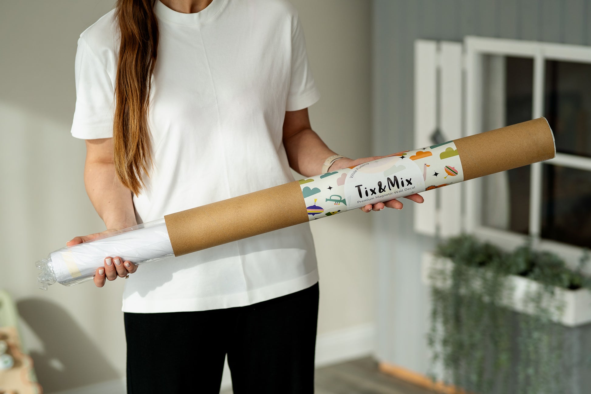 A woman holding a Tix&Mix magnetic wall decal roll.