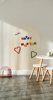 A white magnetic wall decal on a clean white wall with Tix&Mix magnetic letters placed on it.
