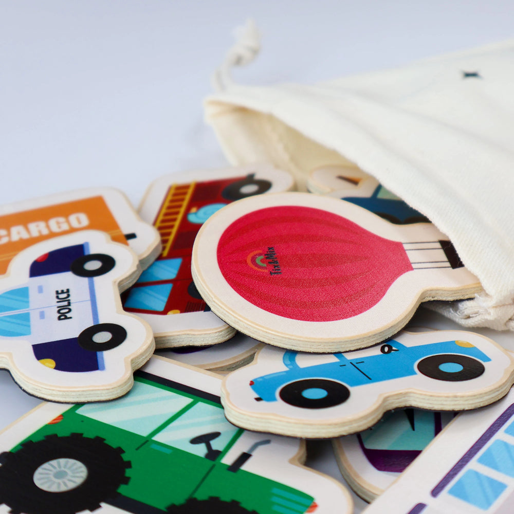 A colorful wooden vehicles playset on a beige pouch, featuring cartoon police car, hot air balloon, bus, and a car.