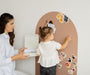 A mother and toddler playing with Tix&Mix magnetic wall decal, placing and organizing animal toys together.