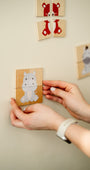 A hand arranging an animal puzzle on a Tix&Mix magnetic wall decal.
