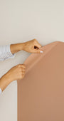 A parent mounting the Tix&Mix magnetic wall decal on a clean white wall.