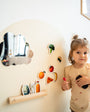 A toddler playing with Tix&Mix magnetic wall decal with food-themed magnetic toys.