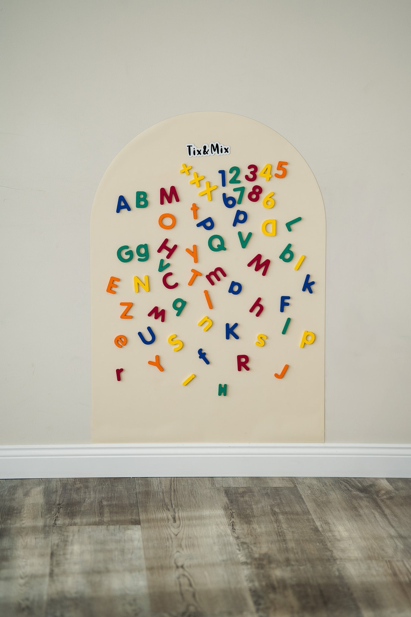Tix&Mix magnetic numbers and letters toys attached to a white magnetic wall decal.
