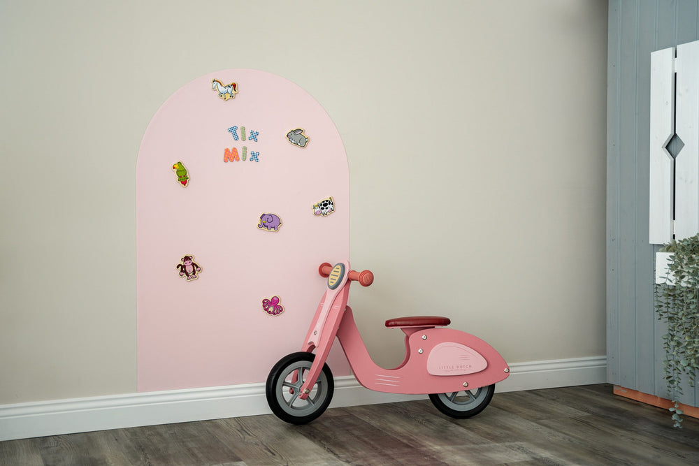 A product display of Tix&Mix pink magnetic wall decal with magnetic animals toys on it and a kiddie bicycle on the side.