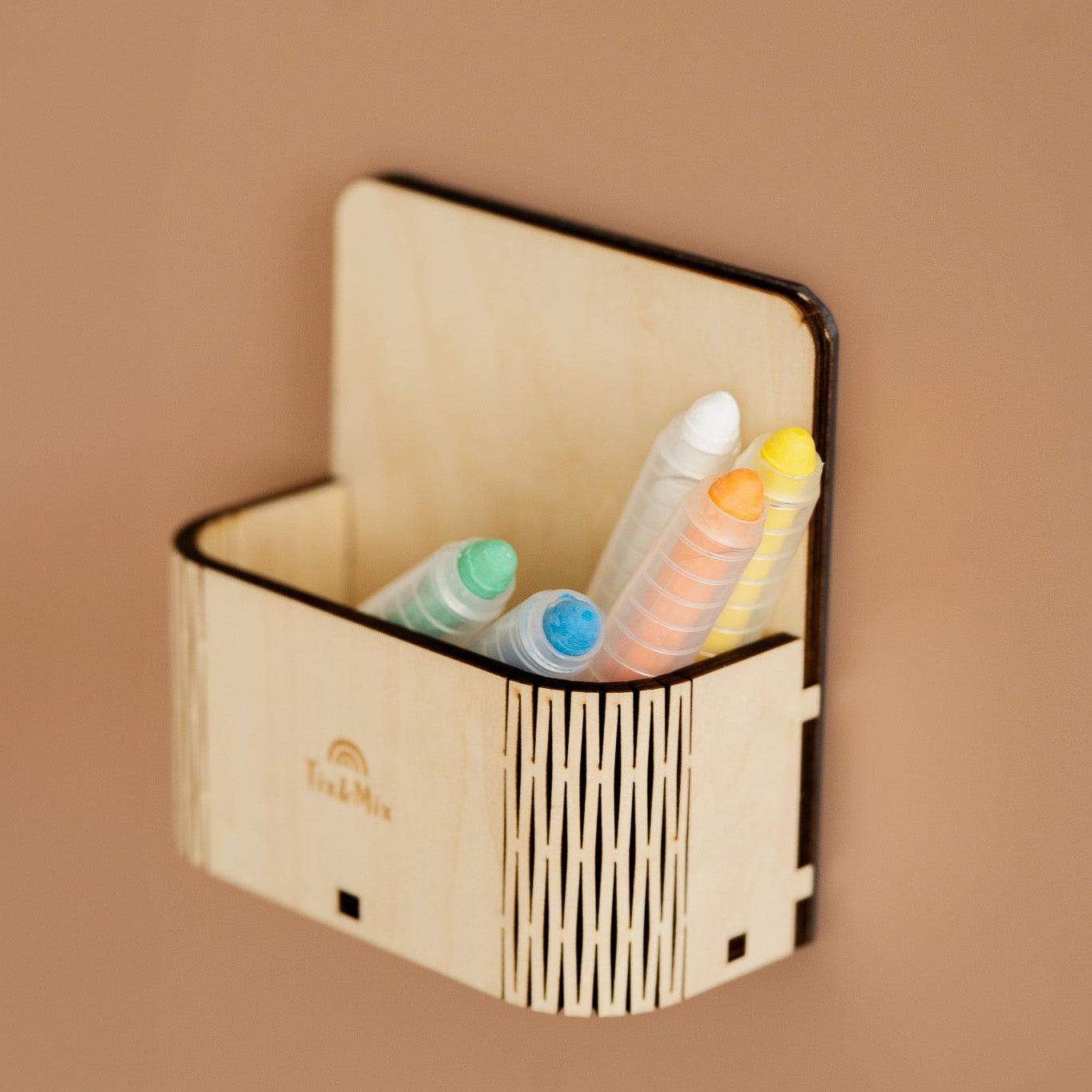 A Tix & Mix wooden magnetic box that contains crayons in different colors inside.