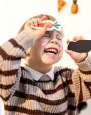 A child playing happily with Tix&Mix wooden magnetic food playset.