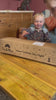 A kid happily playing with Tix&Mix magnetic toys on a brown magnetic wall board.