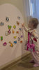 A child playing with Tix&Mix magnetic animal toys on a magnetic wall decal.