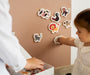 A toddler playing with Tix&Mix explore the animals toy set on a brown magnetic wall decal.